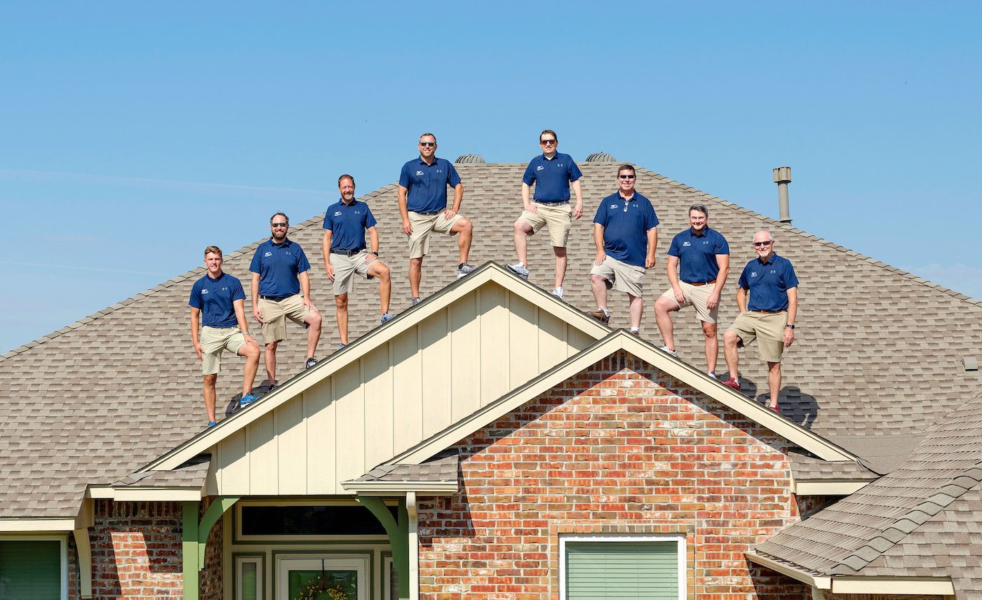 All American team on the roof of a house