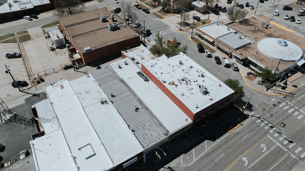 A commercial flat roof with white TPO roofing material being installed on an Oklahoma City business.